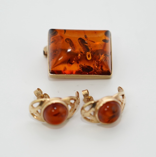 A modern pair of 9ct gold and amber set earrings and a 9ct gold mounted amber brooch, 19mm, gross weight 7.3 grams. Condition - good